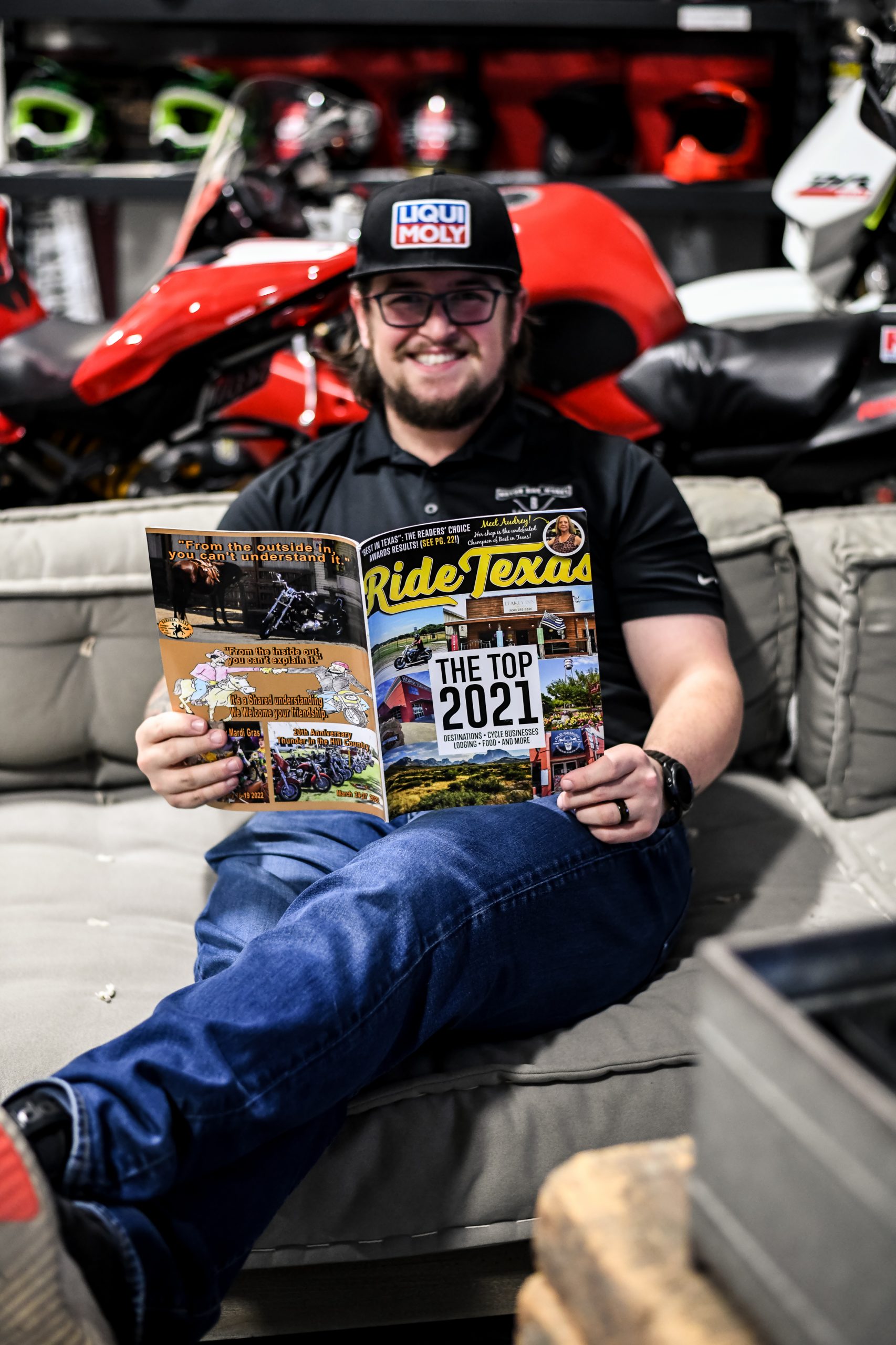 Garrison holding the Ride Texas Magazine sitting on a couch